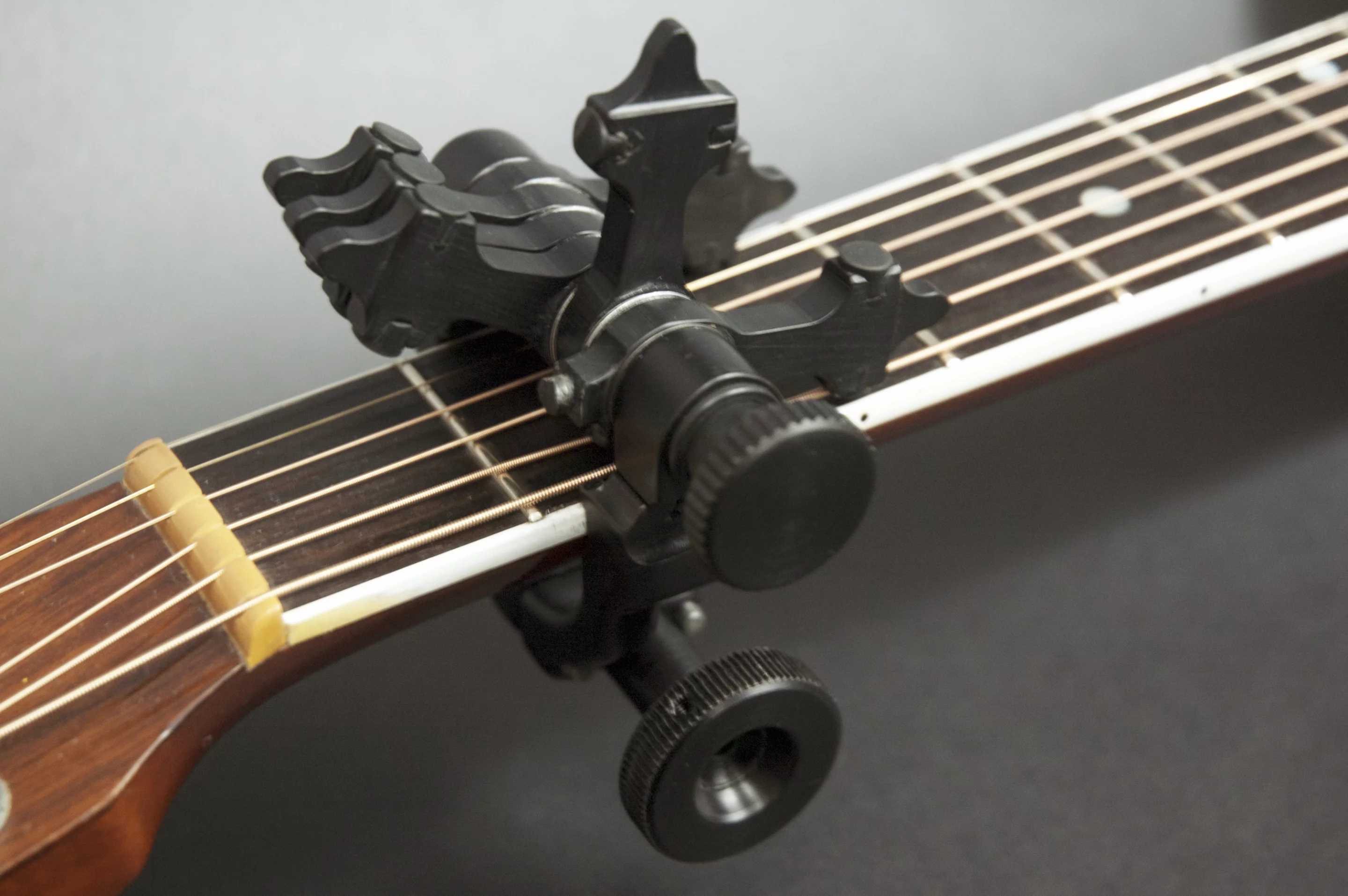 The CapoSonic locks onto the guitar simply by tightening the clamp with your fingers