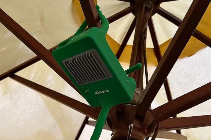 The projector's bendable legs allow for easy positioning on uneven surfaces, or hanging from a parasol frame