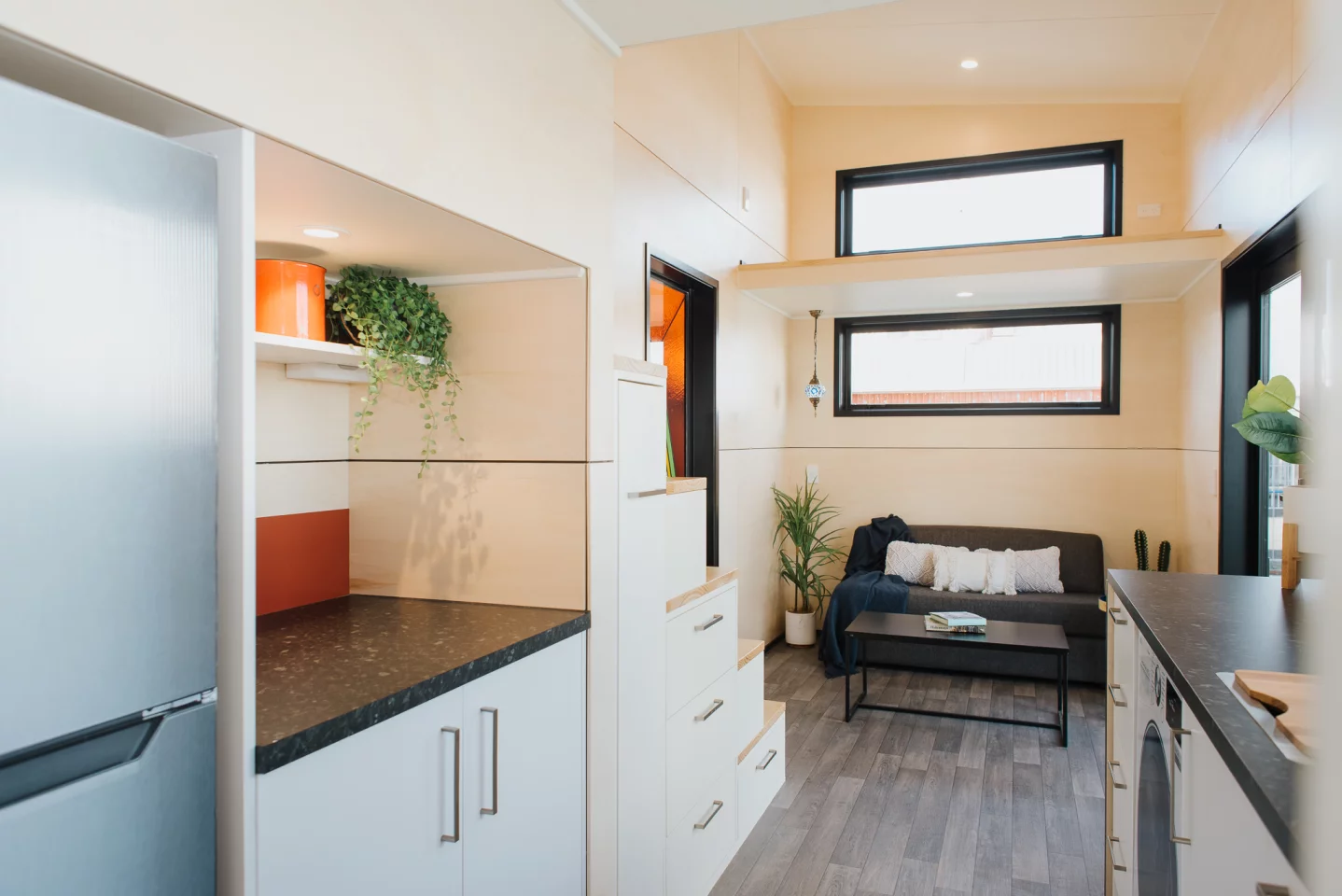 The Daisy Vera Tiny House's living room has a storage loft above it