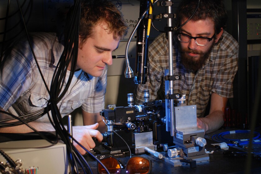 Research physicists Jonathan Matthews (left) and Kostas Poulios aligning the quantum optical chip. The photons are injected into the chip using optical fibre and requires precision alignment.