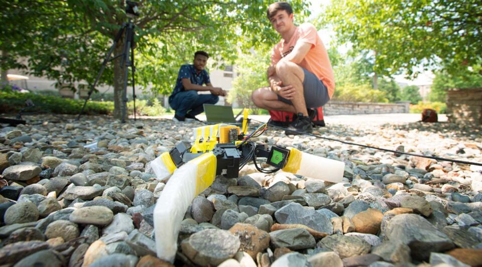 Nnamdi Chikere (left) and John Simon McElroy watch as the robot makes its way over a bed of rocks