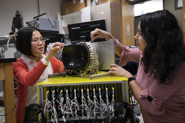 Study authors Zhen Xu and Tejaswi Worlikar tinker with an ultrasound array used to target tumors