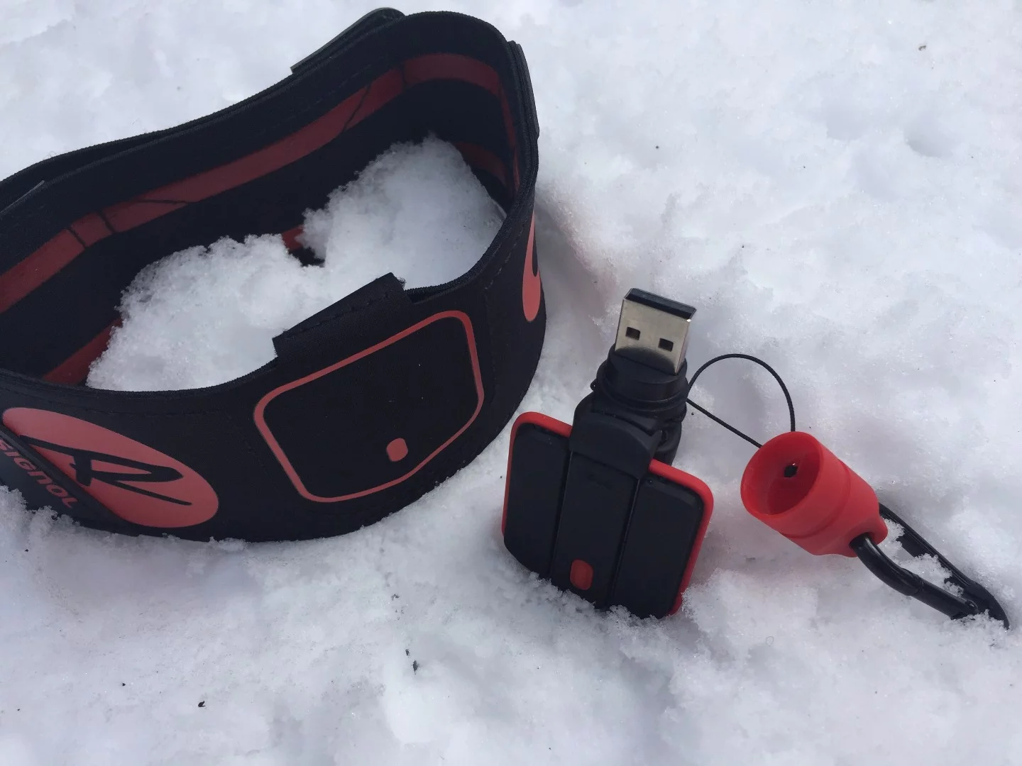 The Rossignol Piq ski sensor is made up of three components: the Piq sensor, a portable charging unit and an ankle strap