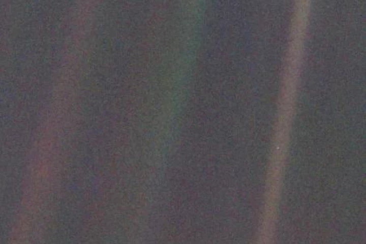 Voyager 1's iconic pale blue dot, with Earth featured as a tiny spec in the light band on the right of the image