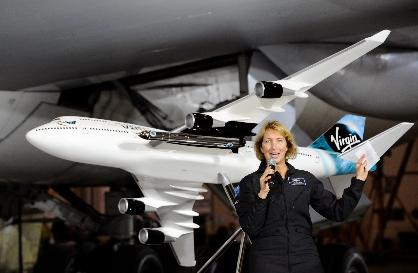 Virgin Galactic pilot Kelly Latimer with a model of Cosmic Girl