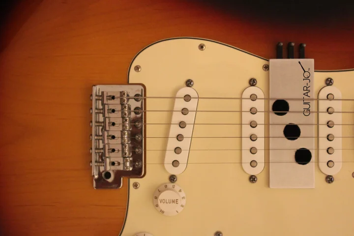 The Guitar-Jo sits under the strings, its three pads acting as dampeners for a banjo sound