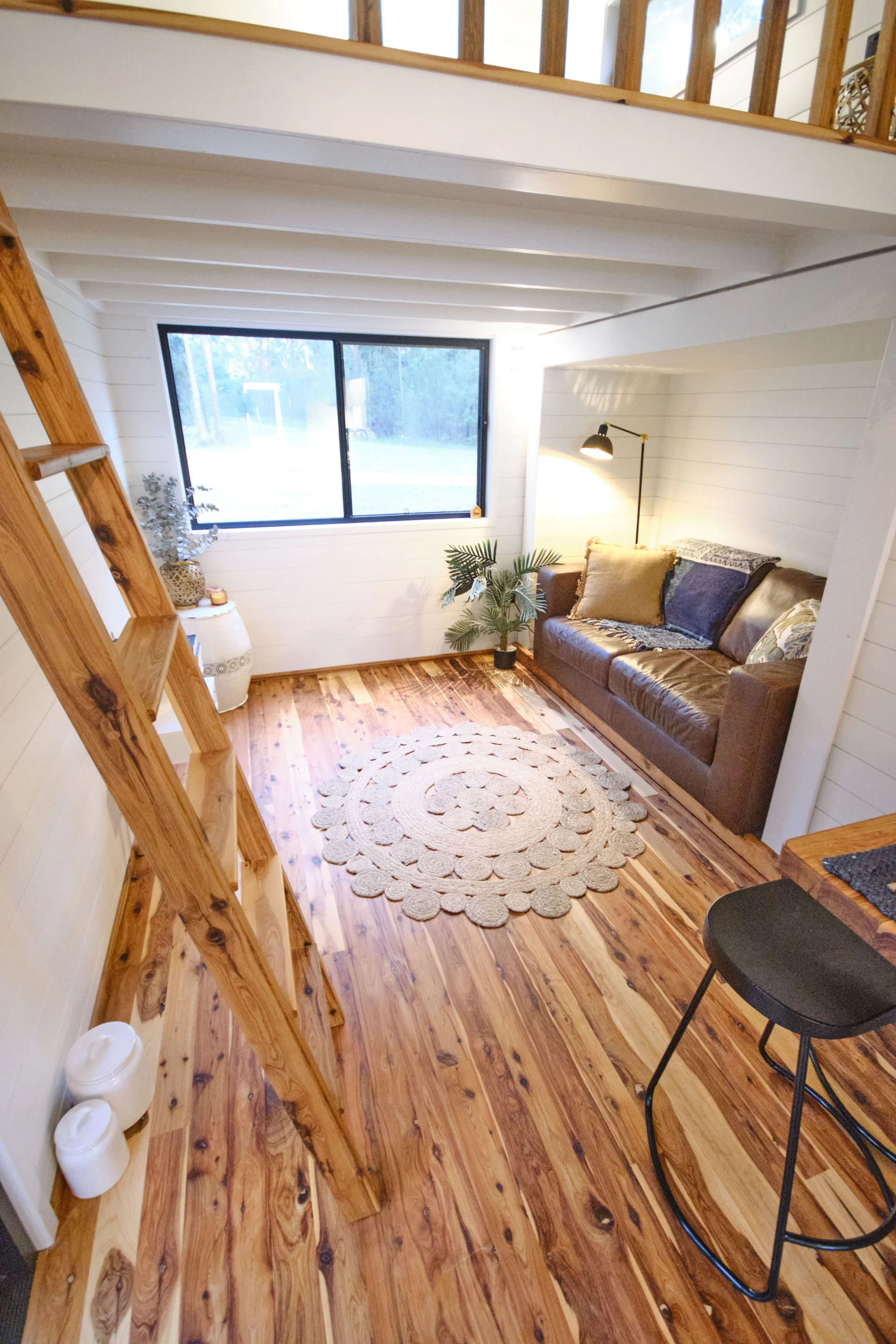 The Grand Sojourner Layout 3's living room includes a sofa and generous glazing