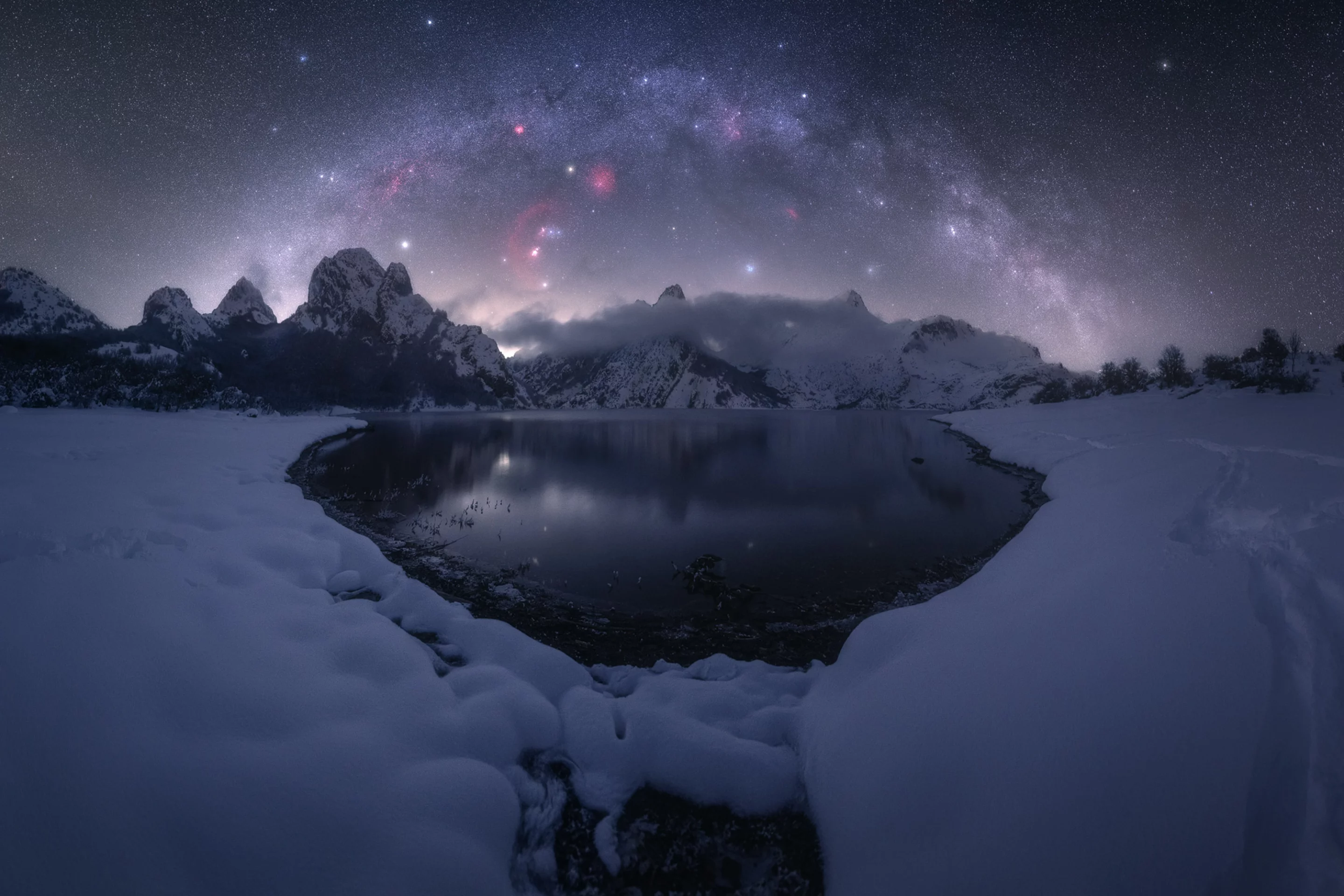 Riaño, captured at Riaño Mountain Reservoir, Spain. The Milky Way glitters over the icy lake, which threatened to freeze the photographer's lens in the bitter cold