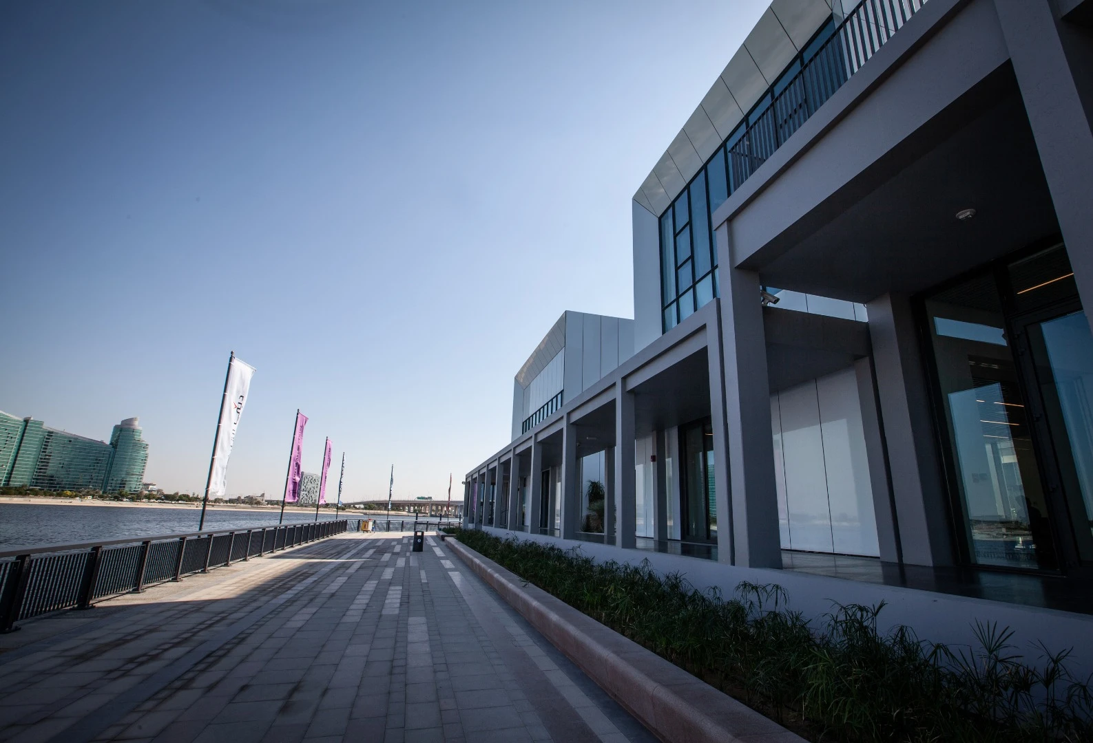 A wooden promenade runs alongside the edge of the Dubai Creek outside the Jameel Arts Centre