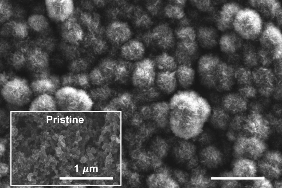 A scanning electron microscope image of the carbon cathode of MIT's new lithium-carbon dioxide battery. Over time carbon dioxide builds up in a solid form on the surface, as compared to the original surface state (inset)