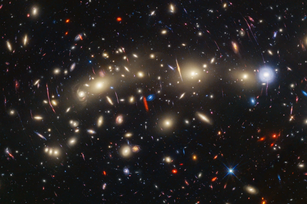 A composite image of the "Christmas Tree Galaxy Cluster" or MACS0416, created by stacking Hubble and James Webb images