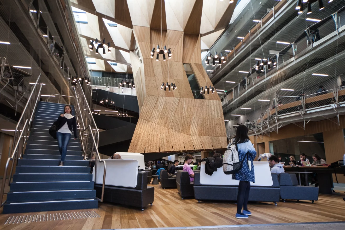 Known as the suspended studio, the internal tower dangles from the ceiling and stops around two meters (6 ft) from the floor where it gives way to groups of students working away underneath