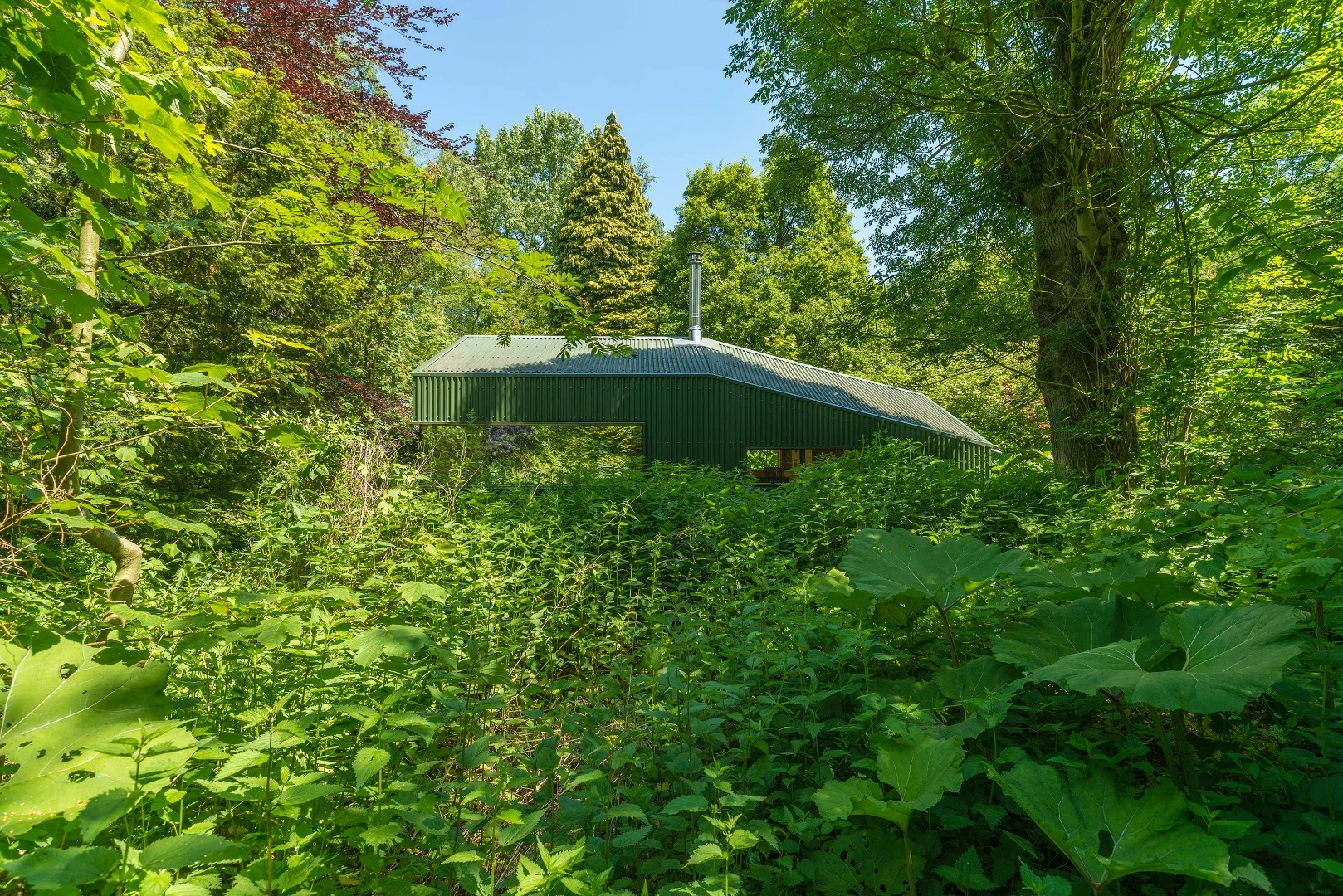 The cabin is built primarily from wood and aluminum, and a painted aluminum roof helps it blend in with its surroundings
