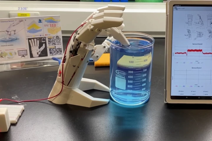 Adhered to the finger pad of a robotic hand, the triboelectric nanosensor checks a liquid sample for mercury contamination