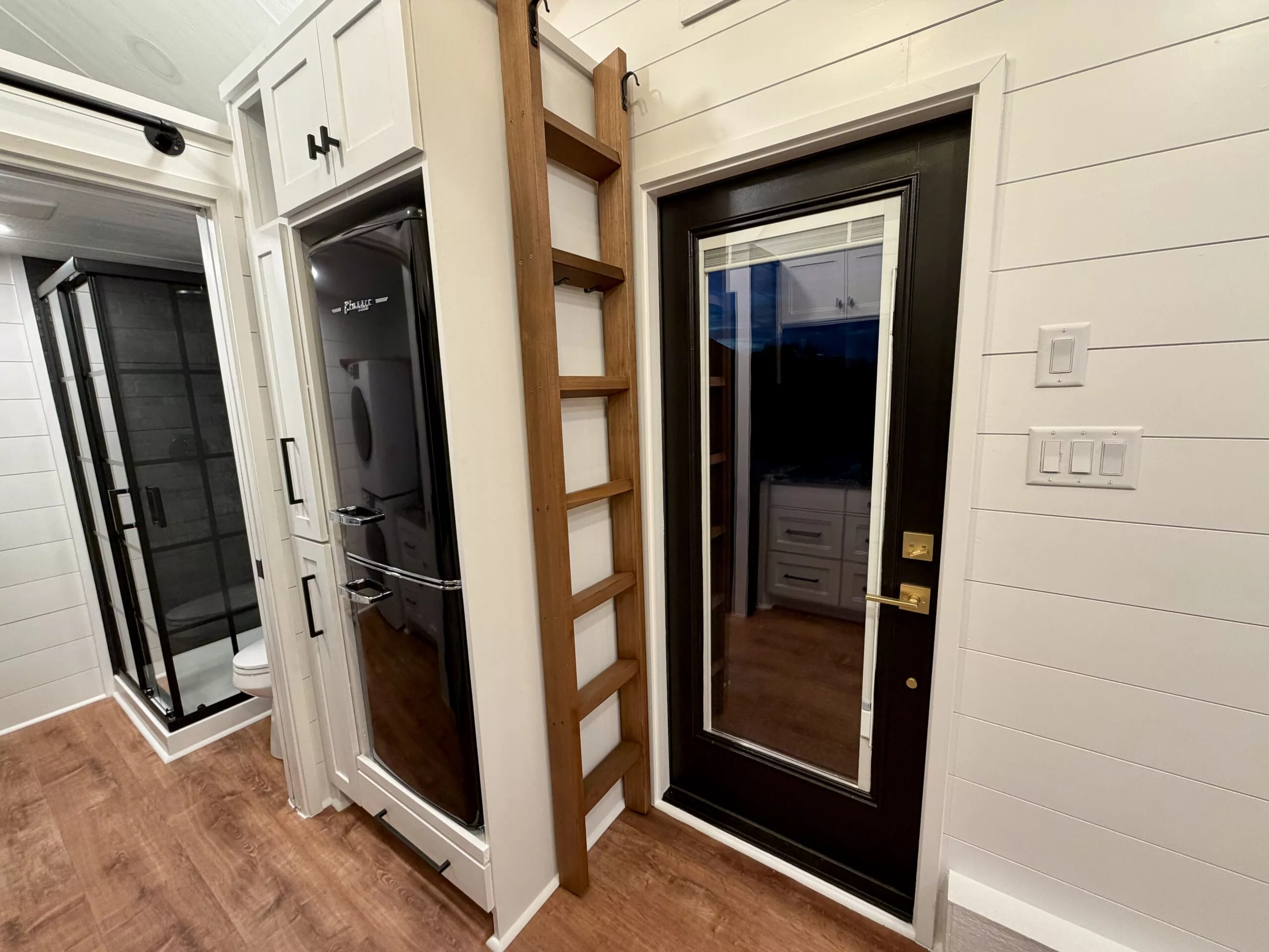 The Betty tiny house's storage loft is accessed by a removable ladder