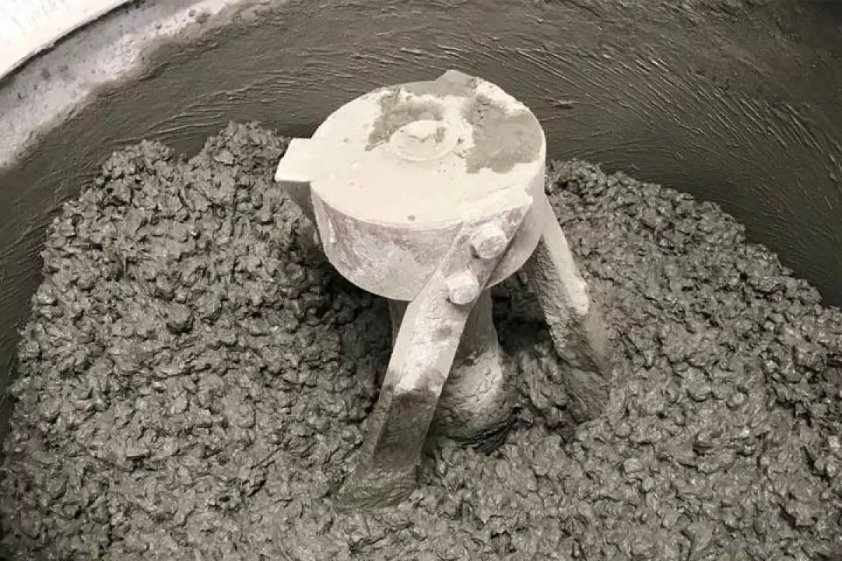 Particles of ground-up tires are mixed into the wet concrete