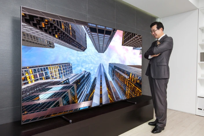 A Samsung executive enjoys the 88-inch QLED TV
