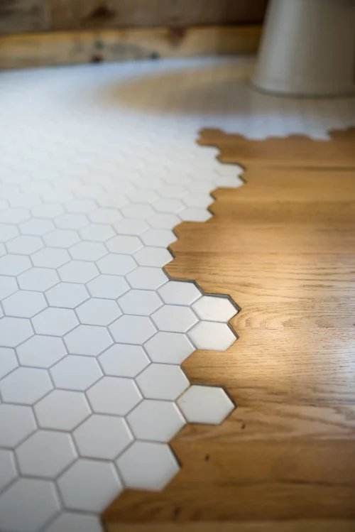 The Legacy tiny house's oak flooring continues into the bathroom, where it meets with honeycomb patterned tiling in a kinda-odd but certainly eye-catching transition