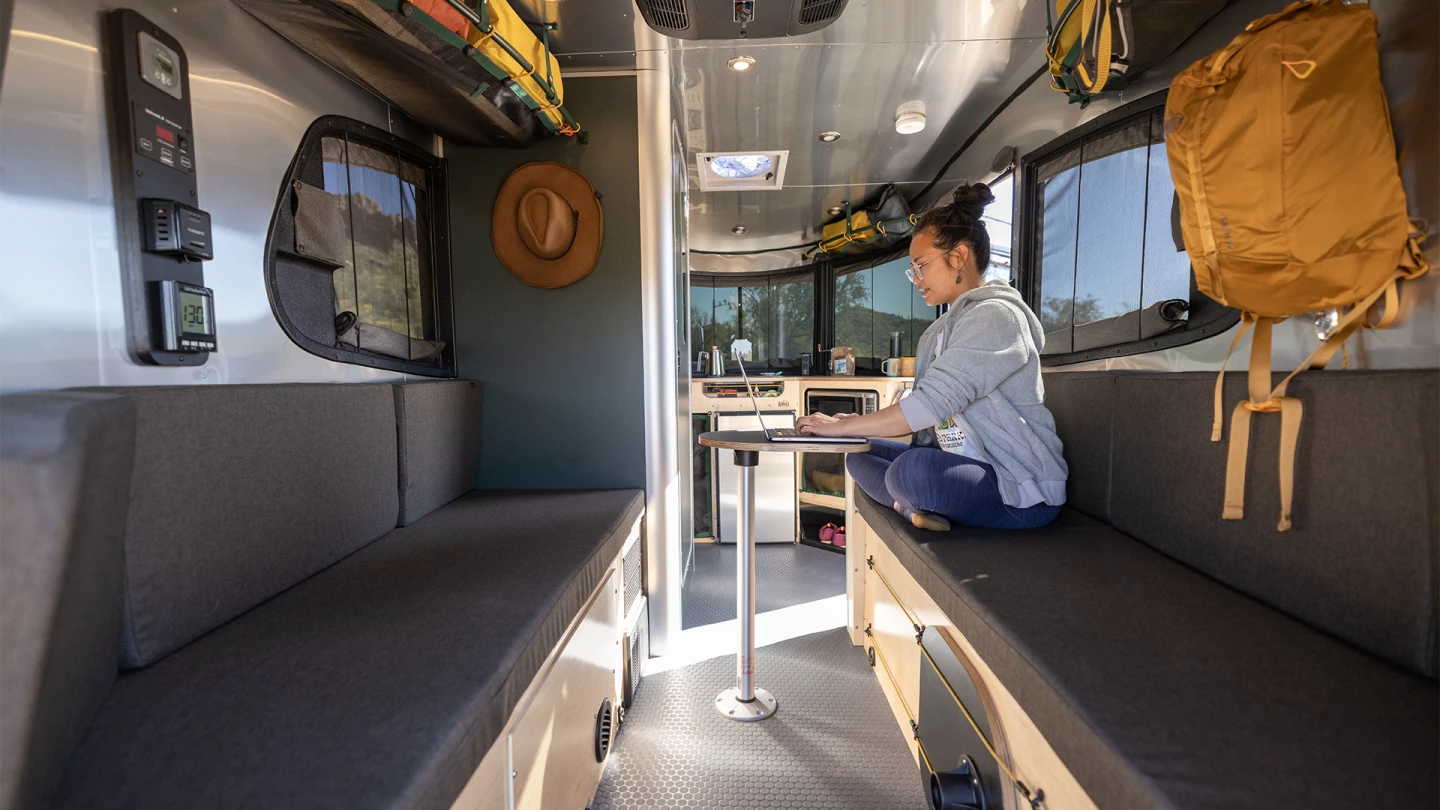 A convertible dinette/living area/bedroom with sleeping space for two features aboard the Airstream REI Co-op Special Edition Basecamp trailer