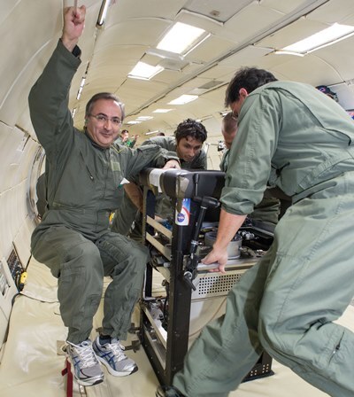 Jamal Yagoobi, left, floats beside a prototype of the new cooling pump during a test flight on a NASA zero-gravity aircraft