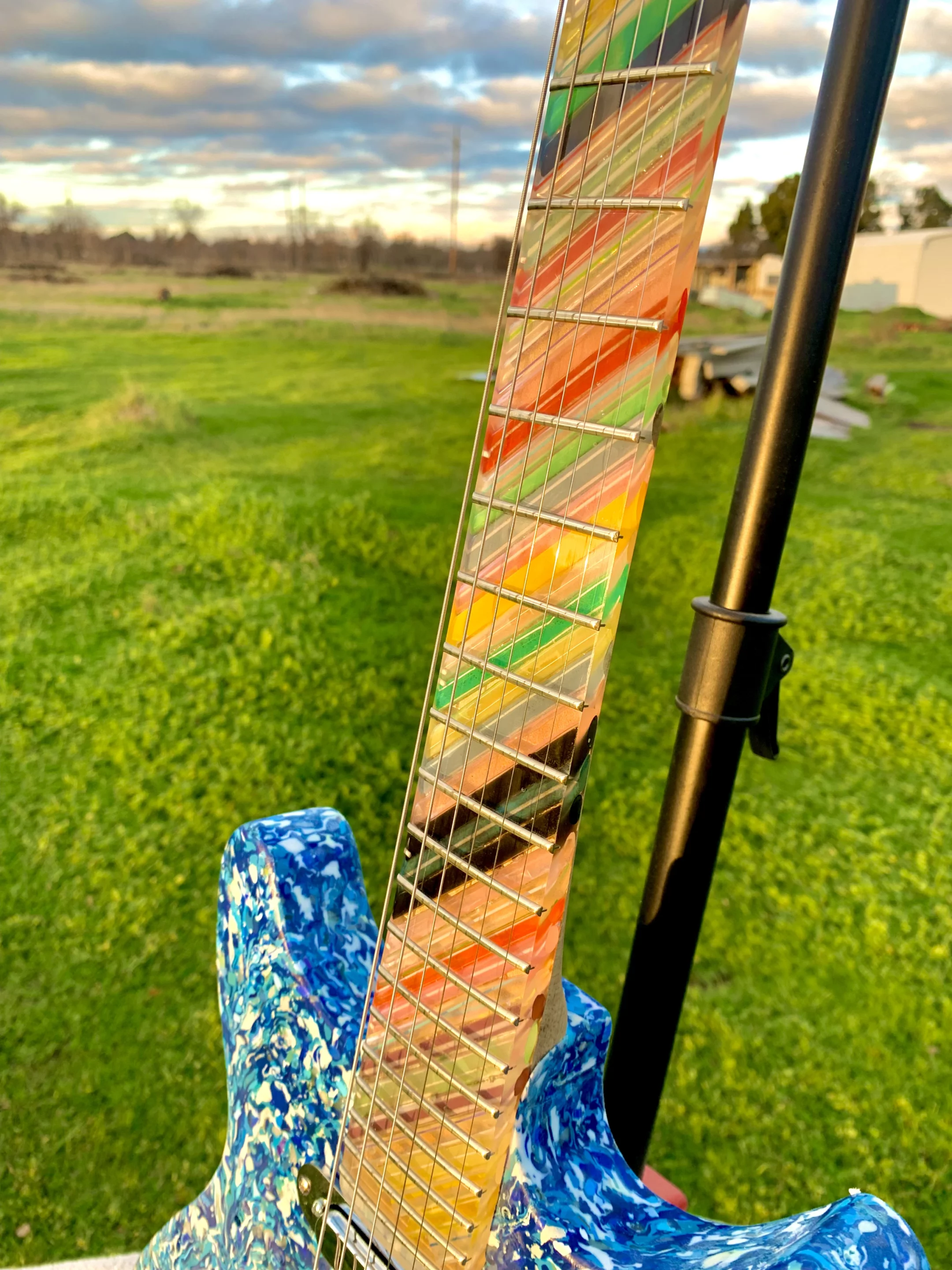 The maple neck is topped by an epoxy fingerboard embedded with colorful plastic s