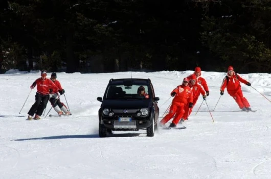 Massa drives the Fiat while the rest of the F1 Ferrari team follows behind