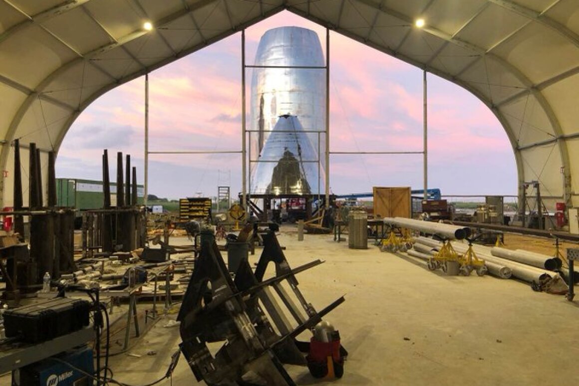 SpaceX's Starship prototype under construction, with a landing leg frame in the foreground
