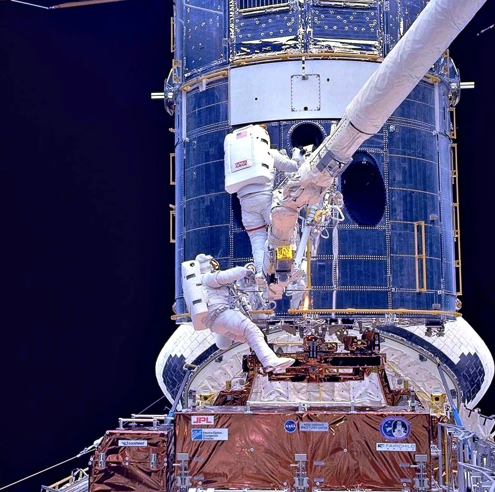 Astronauts fitting corrective optics to Hubble