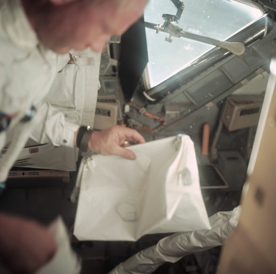 Image showing Buzz Aldrin holding the McDivitt Purse during a LM inspection 55 hours and 41 minutes into the mission (Photo: NASA)