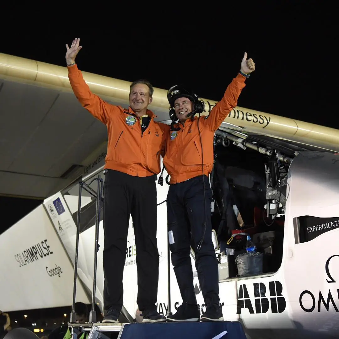 Andre Borschberg (L) and Bertrand Piccard celebrate after Solar Impulse 2 touches down in Abu Dhabi