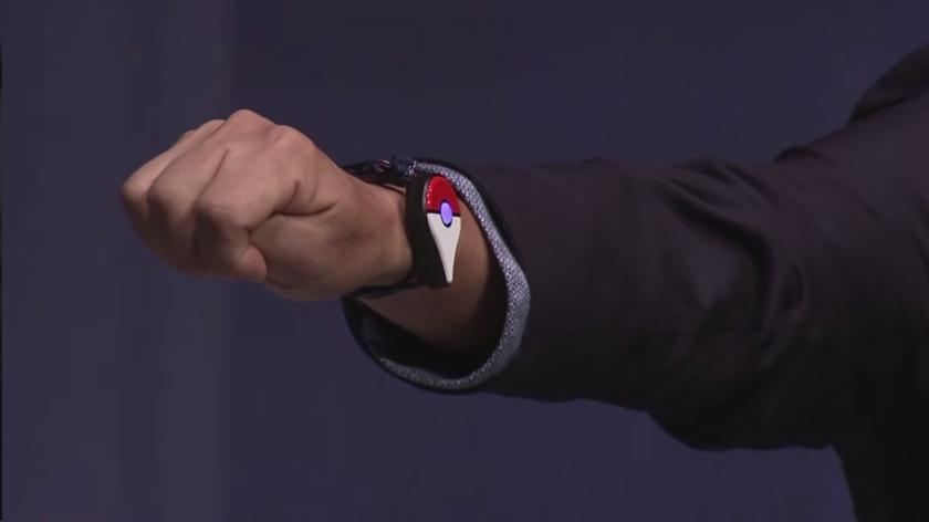 Pokémon CEO Tsunekazu Ishihara models a prototype of the Pokémon Go Plus, a device to add to the new augmented reality world of pocket monsters