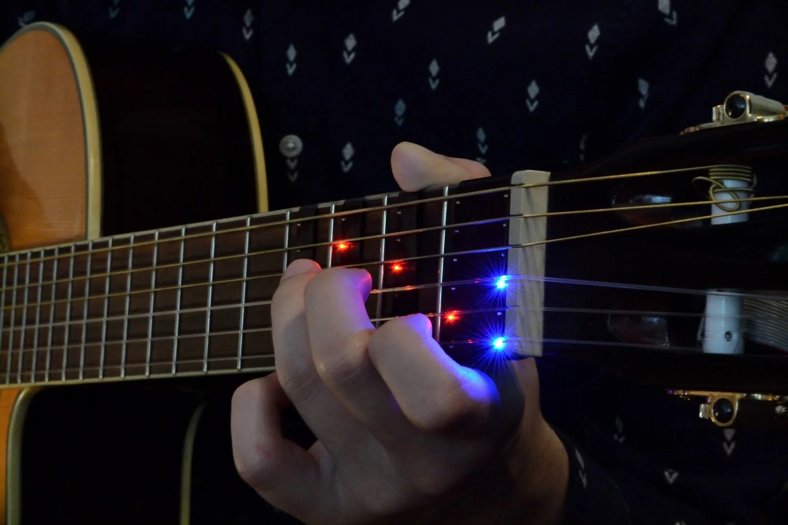 The FretX sleeve wraps around the guitar neck and connects over Bluetooth with a smart device running a companion app