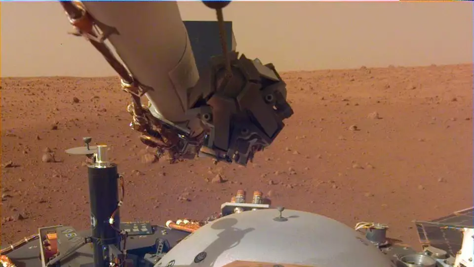 Image from InSight's robotic-arm-mounted Instrument Deployment Camera showing the instruments on the spacecraft's deck with Elysium Planitia in the background