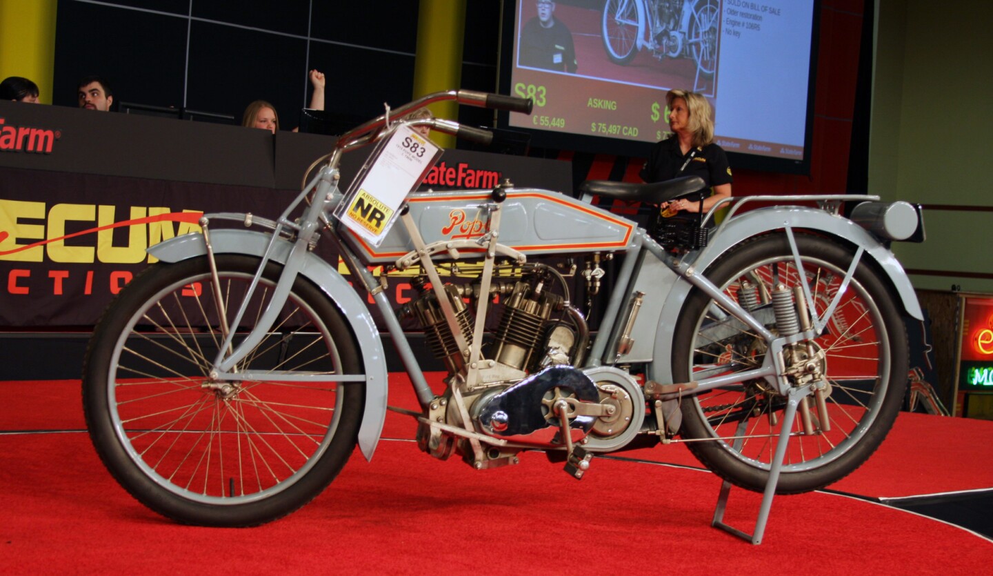 While its twin-cylinder OHV engine was introduced in 1912, the chassis of the Pope lineup was changed in 1913 with a more modern ‘look,’ with squared-off pannier fuel tanks and deeply valanced fenders; the new Pope Model L. Pope motorcycles had a 70 miles per hour (110 km/h) top speed, and the Model L was the fastest production motorcycle in the world when it was introduced. It was also expensive at $250 – the same price as a Model T, although few automobiles could keep up with a Pope… and obviously few motorcycles! The OHV Pope pushed its rivals to look for more speed from their F-head engines and Indian to jump ship to sidevalve motors. The Model L featured a 61 cu-in. (1000cc) motor with Schebler carb and many options, including a two-speed countershaft transmission with Eclipse clutch, and even rear springing via a large plunger spring system at the rear axle. It was rated as an 8 HP model, but actually produced 15.4 HP at the engine, and 13.9 HP at the rear wheel. This 1915 Pope Model L is an older restoration of this hugely important American motorcycle, the first OHV production V-twin, which was only produced until 1918. Popes are very rare. Lot S83 was estimated to sell at $80,000 to $95,000, and eventually sold for $126,500.