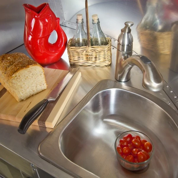 The galley is, as you would expect, compact with an SMEG Italian cooktop and a folding glass top for larger counter space