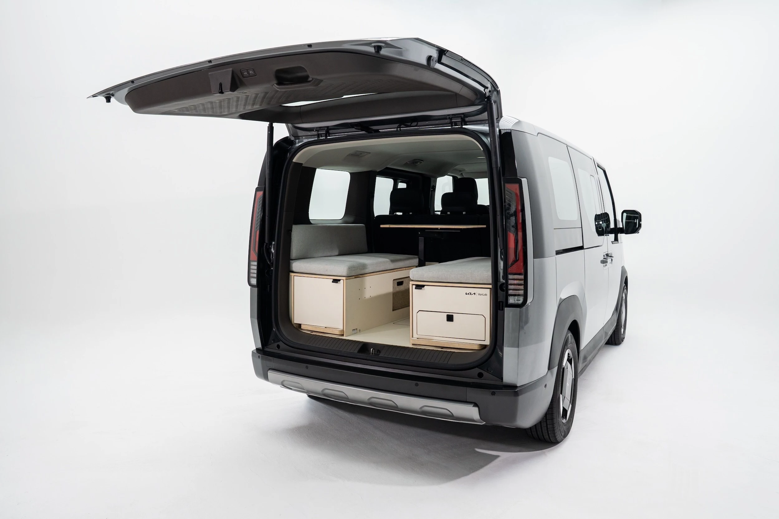 Unlike some camper in a box kits that are all outdoor kitchen/indoor bed, Vanlab's layout for the Kia PV5 includes an indoor dining/workstation/game lounge for escaping the weather