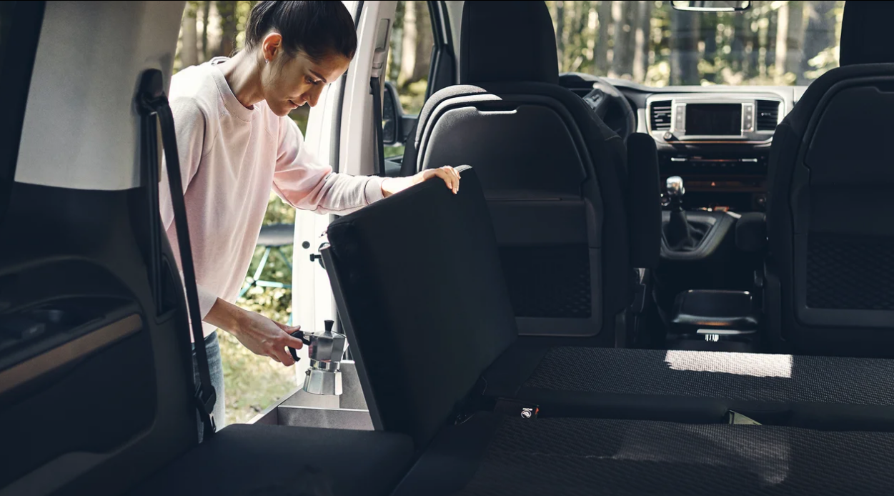 The module just inside the driver-side sliding door is a cushioned bench/bed extension and storage box