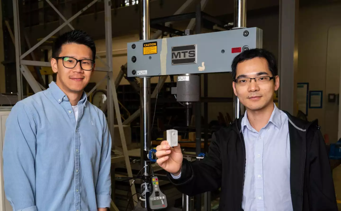 Study lead authors Wei Meng (left) and Bing Deng, with a sample of concrete made with the purified fly ash