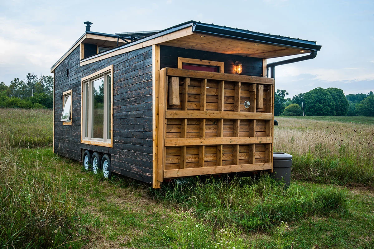 The Greenmoxie Tiny House has a drawbridge deck, which allows the tiny house to remain a reasonable length for towing but then extend when stationary to offer a generous outdoor deck area