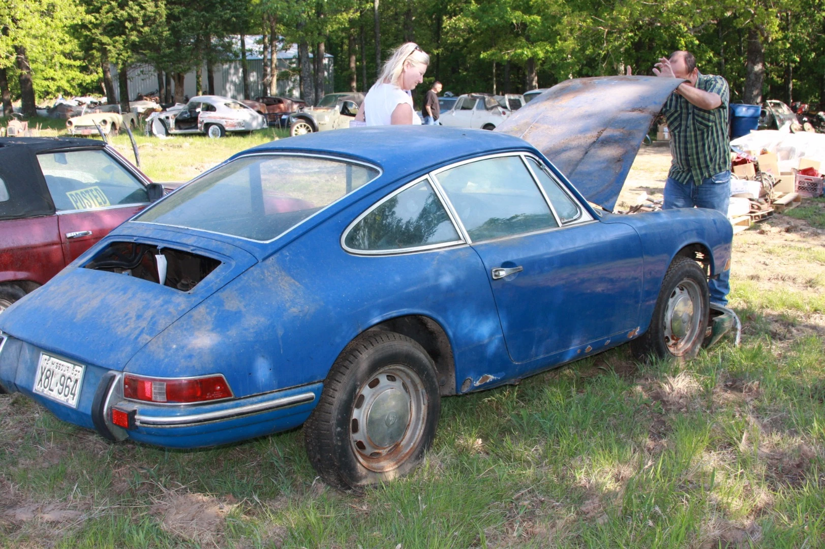 Viewers examine the trunk of the Porsche 912. The engine had been completely disassembled