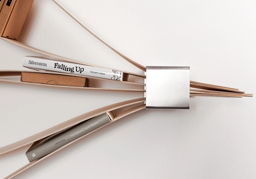 The stainless steel sleeves anchor the flexible sheets of wood at each end of the shelving unit