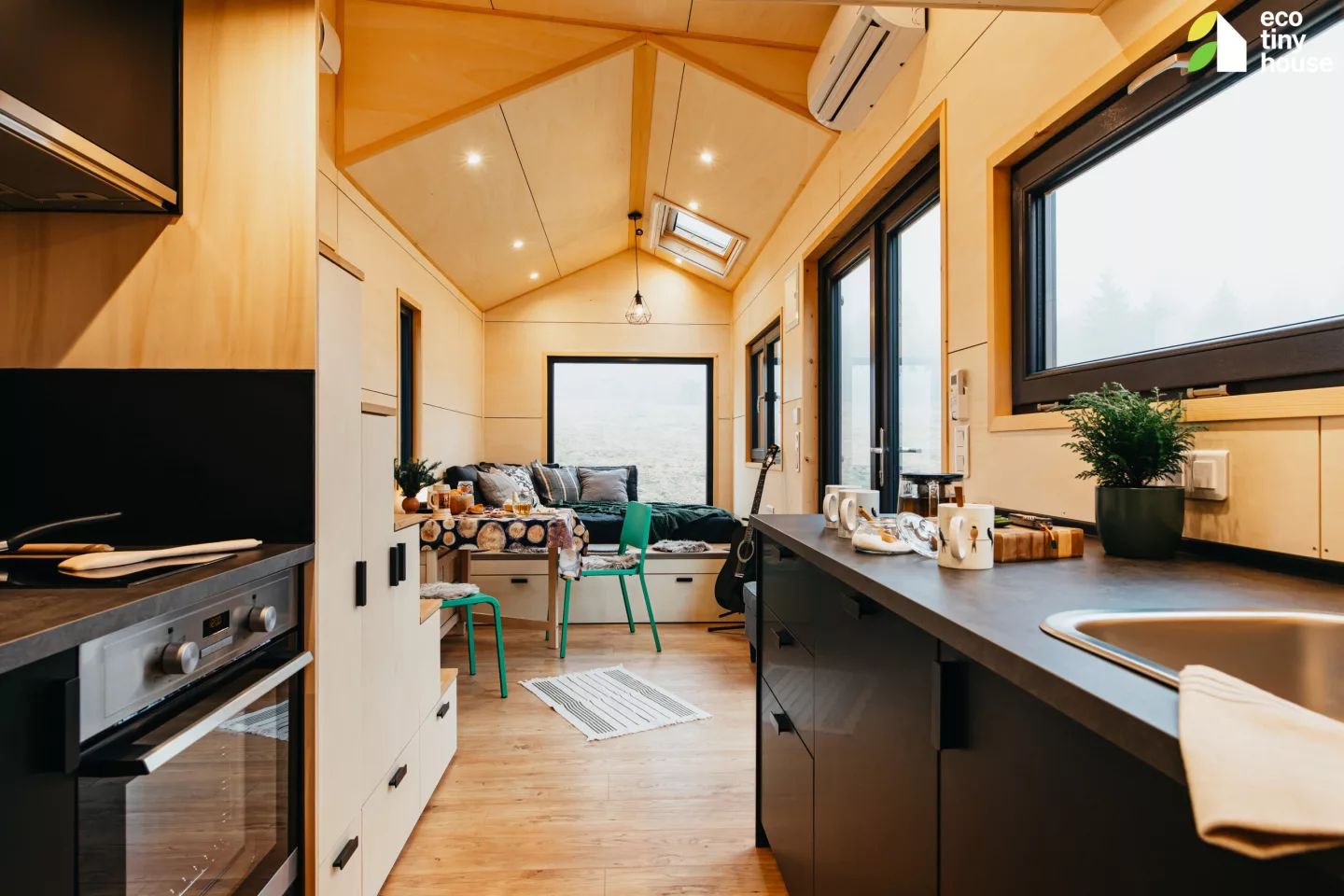 The Tiny Hogwarts' kitchen includes a stainless steel sink, an oven, and an induction cooktop