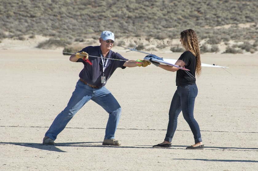 Al Bowers attaches a bungee cord to the Prandtl-d, as Kassidy McLaughlin prepares to release and launch the aircraft