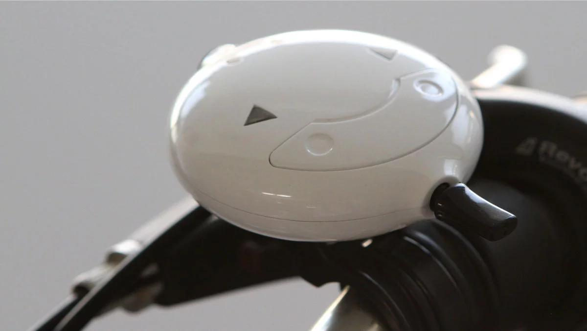 A lever at the front of a handlebar-mounted wireless controller is used to activate the left or right direction arrow via Bluetooth