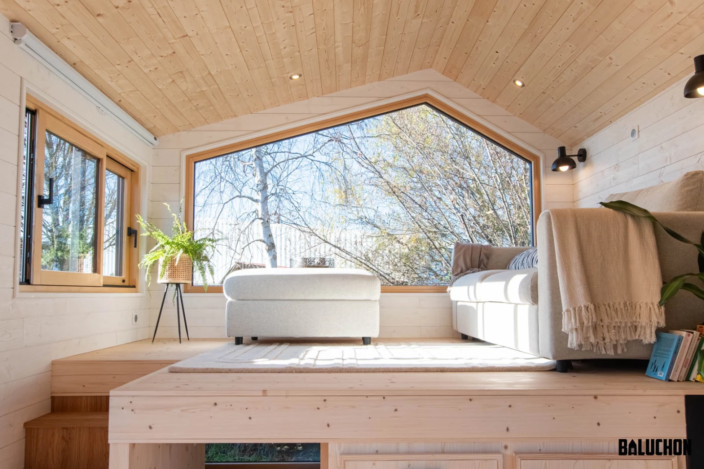 The Ivy Tiny House's living room is raised and has generous glazing