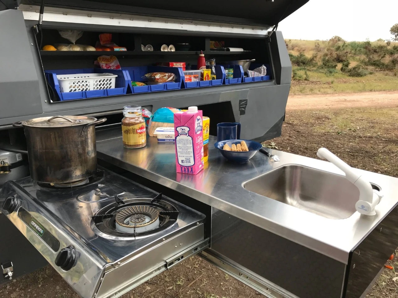 This TTE has a built-in dual-burner stove (not like the portable stove above) and a more pantry-like upper cabinet