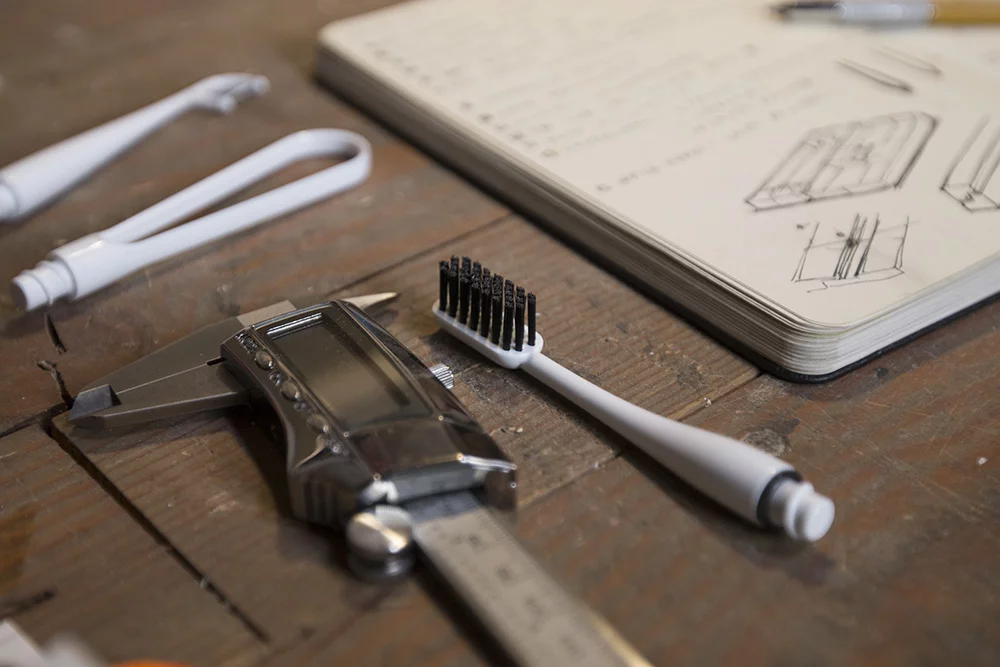 The toothbrush uses bristles made from biodegradable charcoal fibers, while the flossing and tongue scraping attachments are made from polished bamboo composite