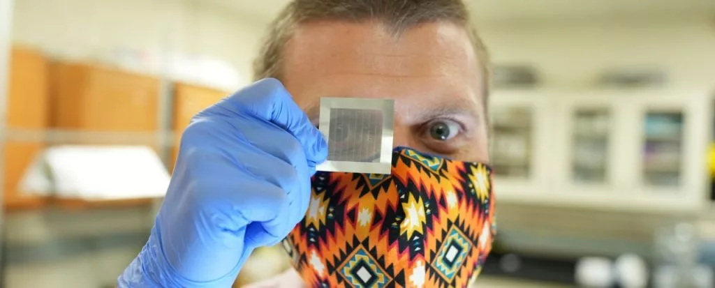 Researcher Jonathan Boreyko holds up a section of synthetic feather material