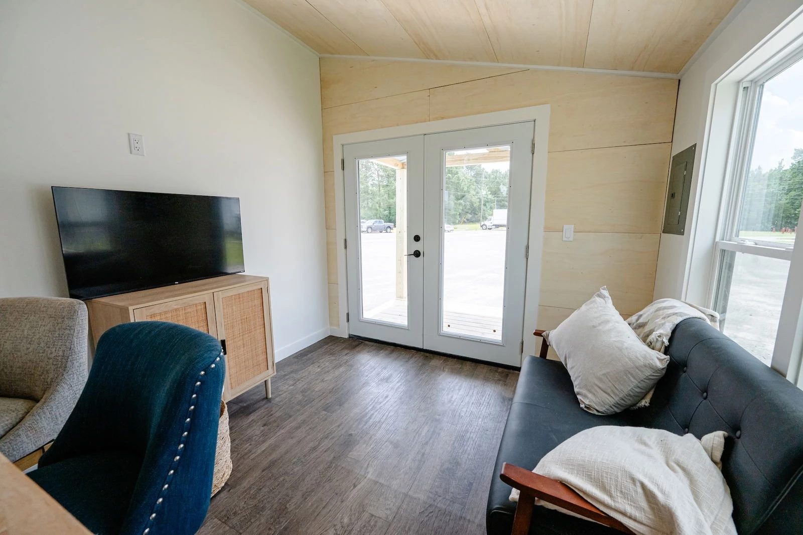 The Rowan's entrance opens onto the living room, which includes a sofa, TV, and a cabinet