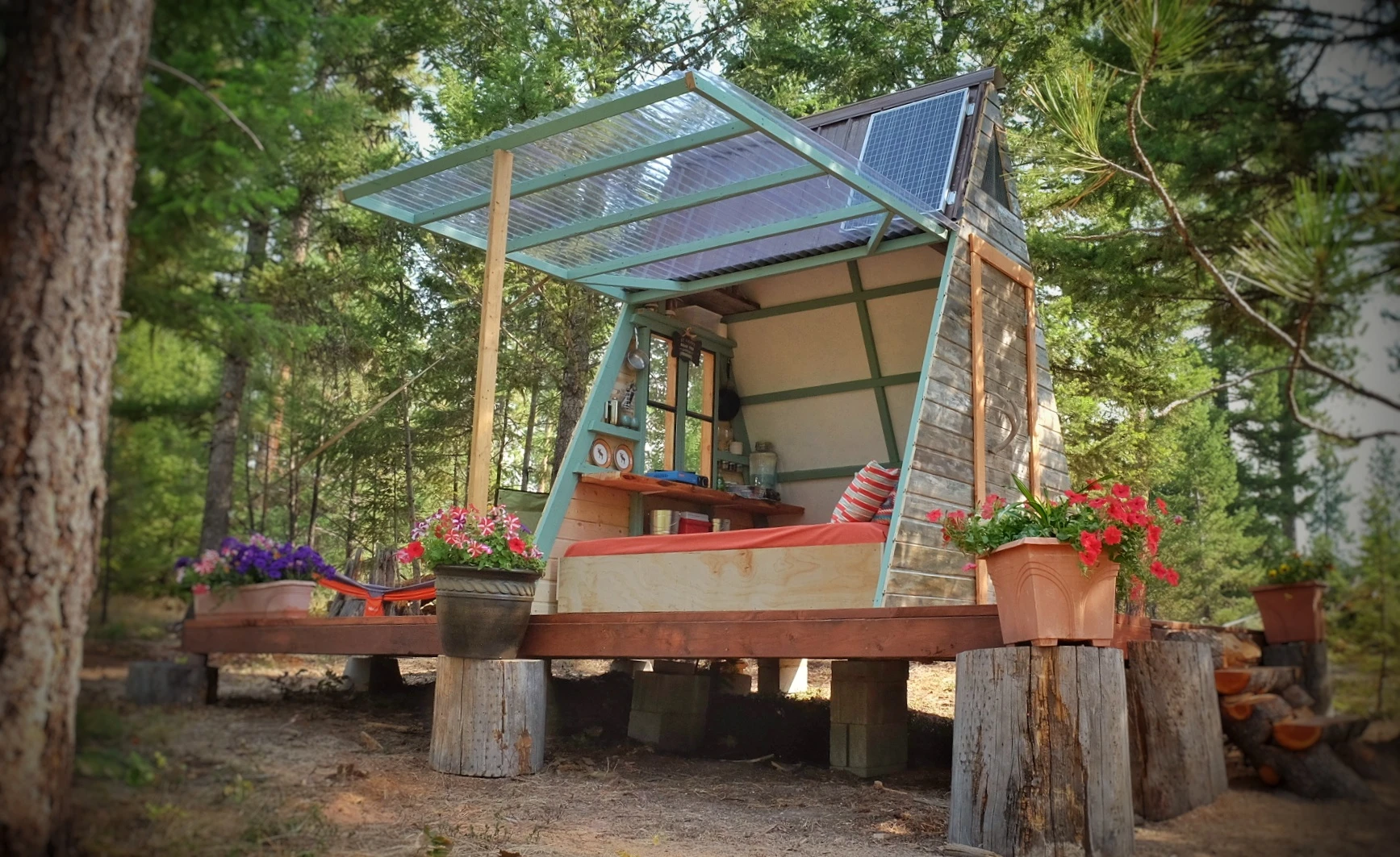One of the cabin's walls lift upwards to open the dwelling to the outside